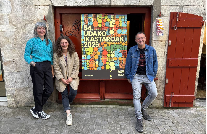 Argazkian UEUren Udako Ikastaroak iragartzen dituen kartelarekin ageri dira ezkerretik eskuinera Irati Iciar Madinabeitia, Oihana Galé Zamponi eta Aitor Bengoetxea Alkorta