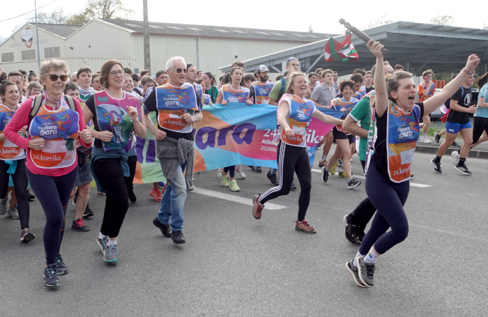 Oihana Galé Zamponi  Korrikaren lekukoa eramaten. Eskuak gora eta ozen oihukatuz, atzean beste lekuko eramaileak dituela. 