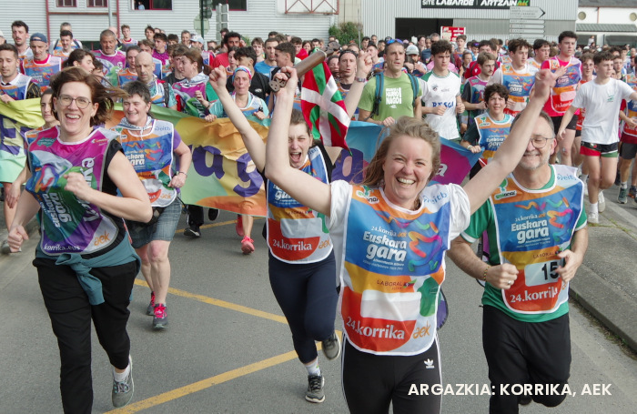 Pauline Guelle Lefort Korrikaren lekukoa eramaten. Eskuak gora eta irribarrez. Korrikaren prentsa bulegokoak egindako argazkia